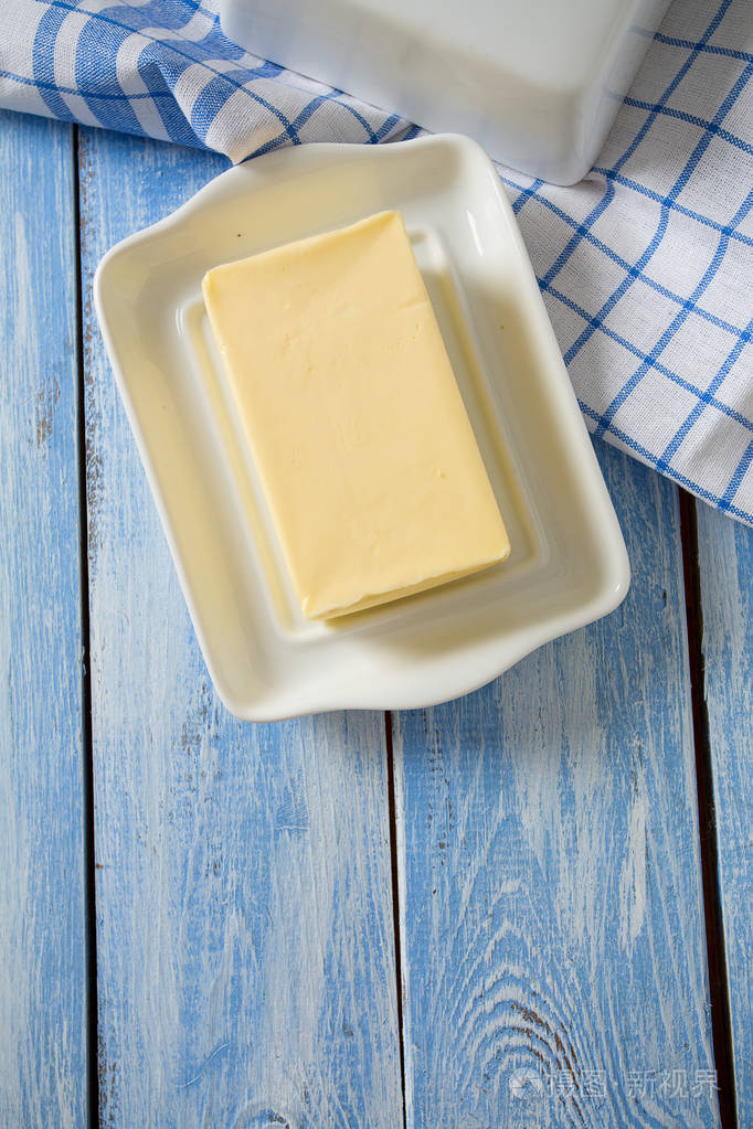 蓝色木制表面的黄油盘
