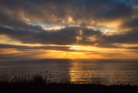 戏剧性的海岸日落，阳光透过云层从特拉尼亚小径，兰乔，帕德斯加利福尼亚。