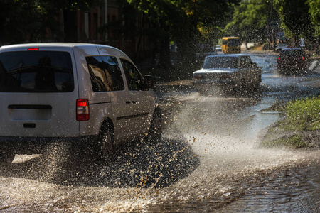 在暴雨造成的洪水中驾驶汽车在洪水泛滥的道路上行驶.