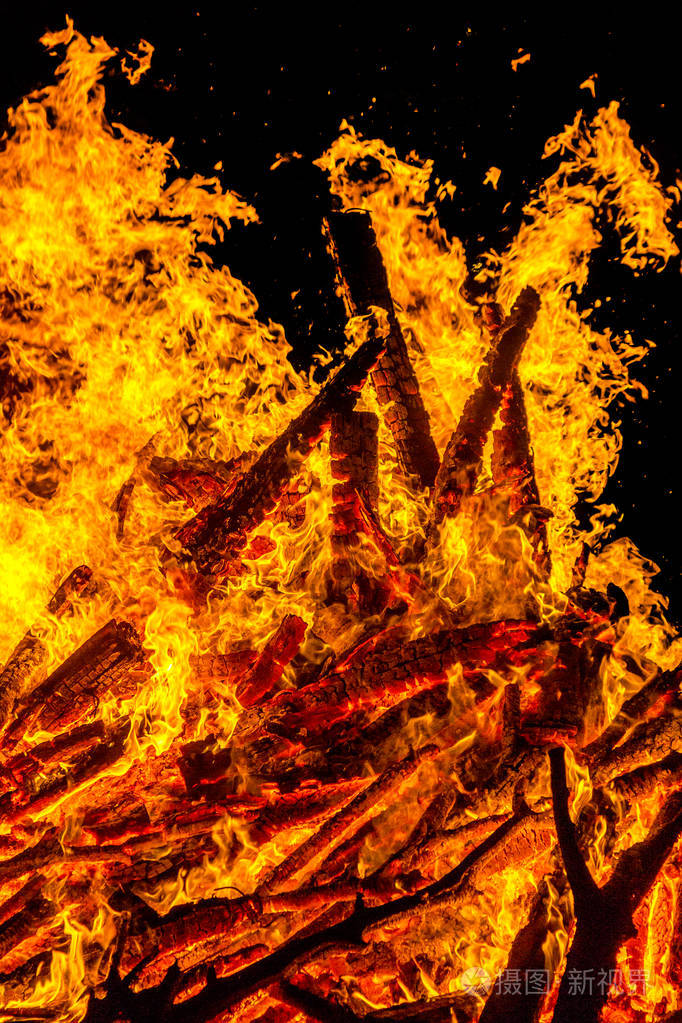 夜晚燃烧的篝火把火焰梳理成质地和背景结实的树枝燃烧着森林的火树