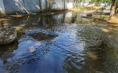 大雨期间的水流和街道污水的堵塞。 暴风雨下水道中强烈飓风期间的水流。 污水雨水系统沿道路排入排水系统