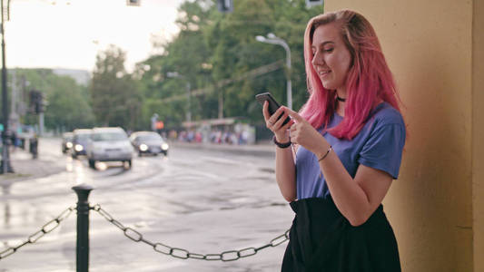 在镇上使用电话的粉红色头发的妇女