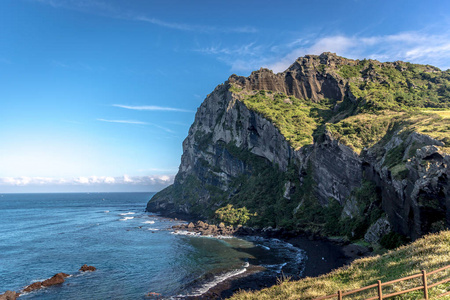 韩国济州岛上一座巨大的岩石山，顶部有绿色植被