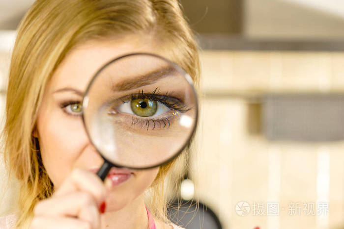 金发女人拿着放大镜调查一些事情仔细观察试图找到解决办法