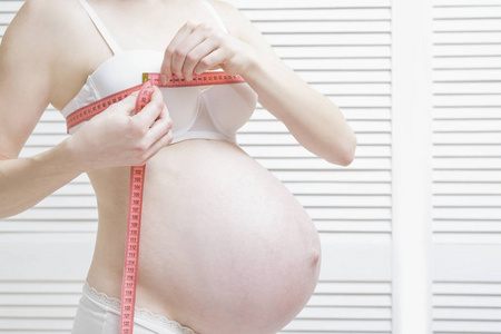 孕妇测量乳房体积。 怀孕概念