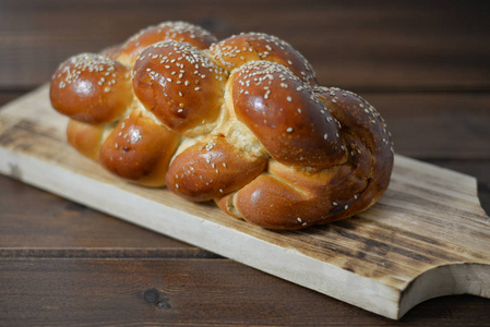 传统的犹太甜沙拉面包在木桌上的木盘背景与复制空间