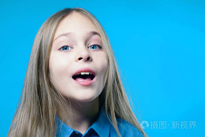 一个可爱的女孩的肖像张开嘴蓝色背景