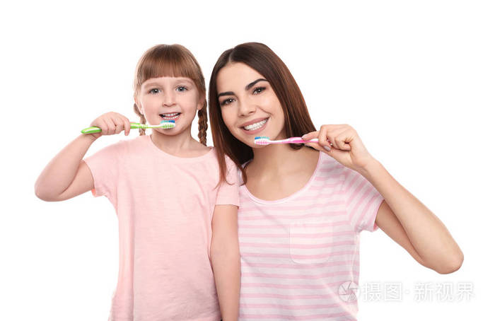 小女孩和她妈妈一起在白色背景下刷牙