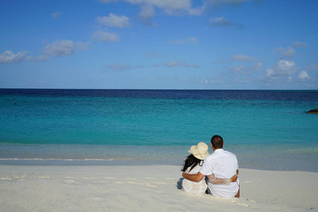 情侣坐拥在海边沙滩后景