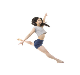 一个穿短裤和T恤的年轻女孩跳现代芭蕾。 演播室拍摄的白色背景。 孤立的图像。