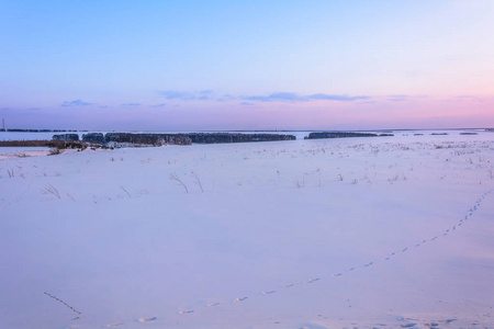 冬天的日落在天空中嬉戏，田野在雪中嬉戏