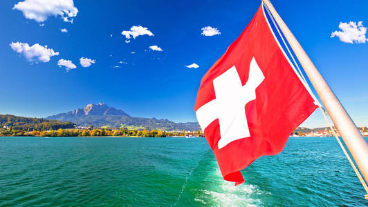 瑞士国旗在船上流淌的卢泽恩湖与皮拉特斯山背景瑞士风景名胜区