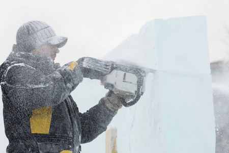 雕刻家用电锯把冰轮廓从冰上剪下来，以供圣诞之用
