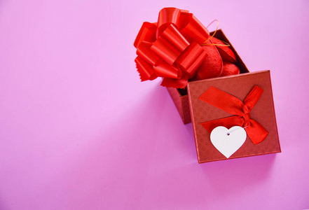 开放礼品盒红色情人节概念红色礼品盒带蝴蝶结红心满礼盒粉红色背景惊喜礼品盒节日情人