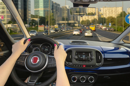 通往交通在通往城市的道路上开车的女人照片