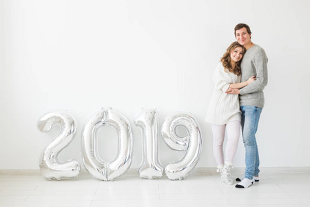 新的2019年是来的概念愉快的年轻人和妇女与银色数字在白色背景