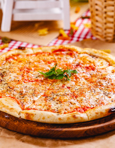 意大利比萨饼玛格丽特，西红柿和莫扎雷拉奶酪在木切割板上。 近点
