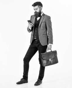 大胡子男士穿着智能西装, 使用智能手机.