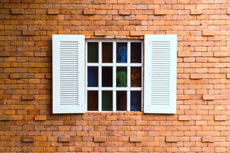 砖墙上漂亮的白色老式窗户照片