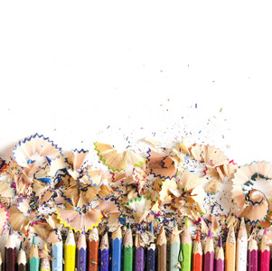 绘图工具背景。 许多彩色铅笔框架，锯末和刨花在白色复印空间平躺。