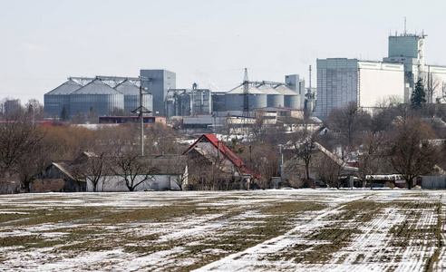 村背景上的农业综合体和粮食仓库..冬天的照片。