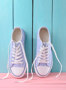 s retro hipster sneakers with white laces on a pink wooden floor