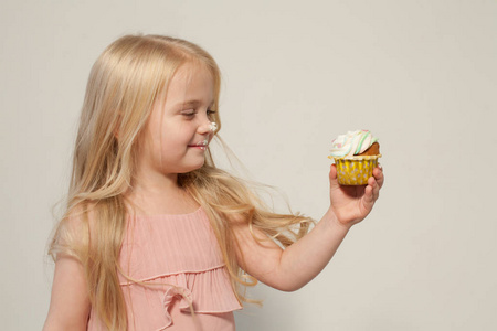 小女孩吃甜蛋糕与奶油纸杯蛋糕