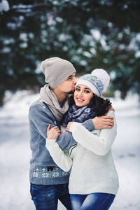 冬天穿毛衣拥抱在公园里的男人和女孩