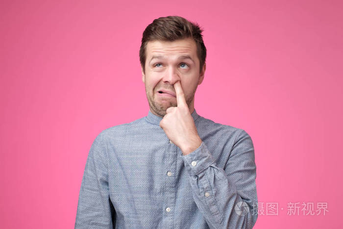 年轻的欧洲男人正在挖鼻子