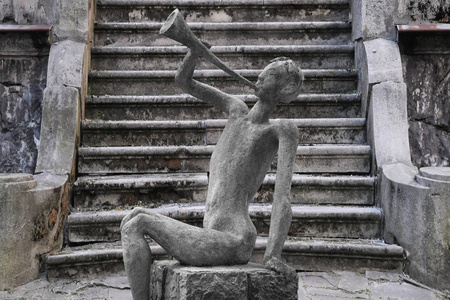 一个人在古老的历史楼梯上吹喇叭的石雕...