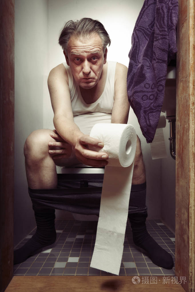 穿着衬衫的老人在厕所享受他的时光