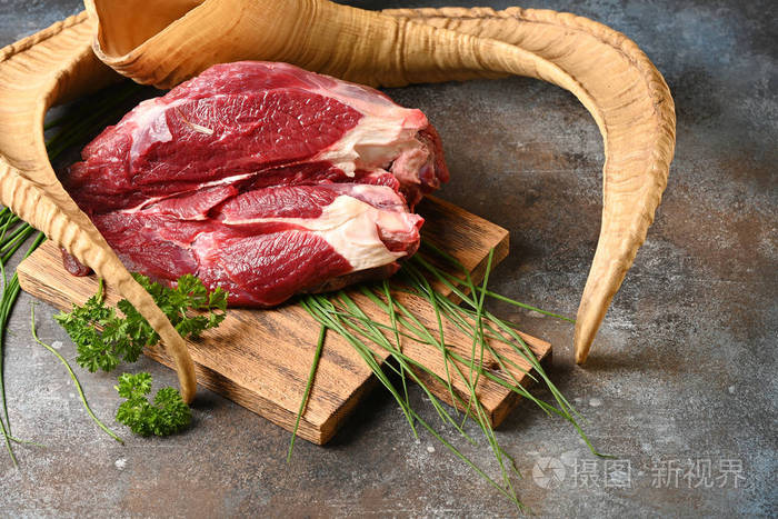 新鲜的深色肉类, 配以在棕色木制切菜板上烹饪的食材