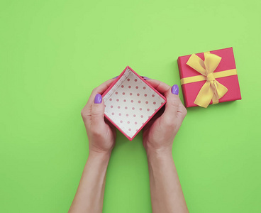 s hands hold a gift box on colored paper