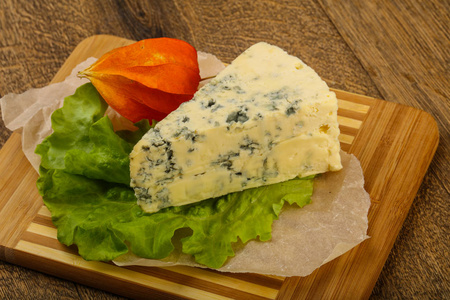 木制背景上有沙拉叶的蓝色奶酪