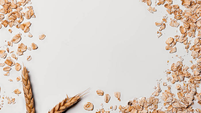 一捆燕麦植物与燕麦片在光背景.中间的文字位置