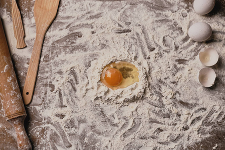 制作面团用面粉和蛋黄覆盖的木桌的俯视图