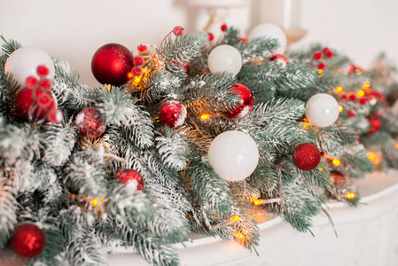 近距离观看美丽的冷杉树枝与闪亮的红色和白色鲍布尔斯圣诞假期背景。