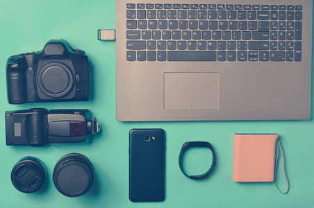设备摄影师笔记本电脑智能手机智能手表电源库在蓝色背景。 自由职业概念小工具，工作对象，顶视图平面洛杉矶