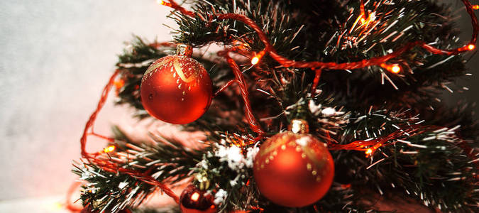 美丽的圣诞树，有红色闪亮的球和明亮的花环