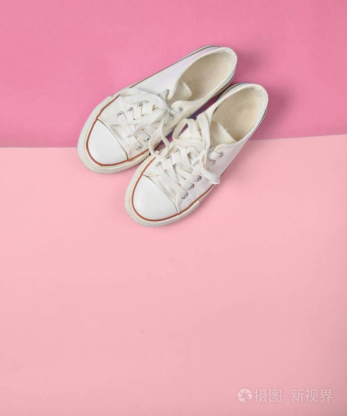 旧的复古运动鞋与白色鞋带在蓝色粉红色的糊状背景极简主义顶级vi