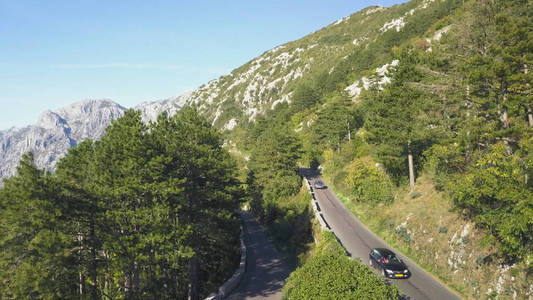 山间道路交通的顶部视图。股票。夏天在山道上的交通。摩托车司机去蛇形路上探险。夏天度假旅游和山脉