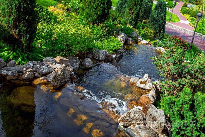 人工级联瀑布式流水下到行人人行道配有灯笼供步行和娱乐