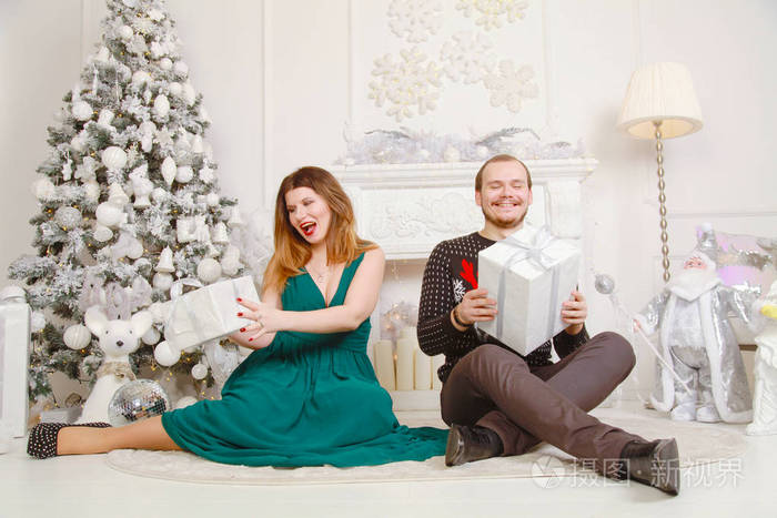 甜蜜的一对夫妻庆祝新年,在白色在白色背景上微笑