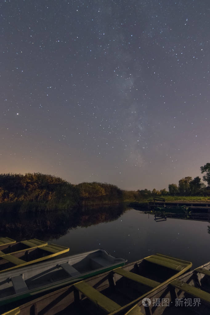 夜晚湖面上星星和树木的倒影. 游艇码头