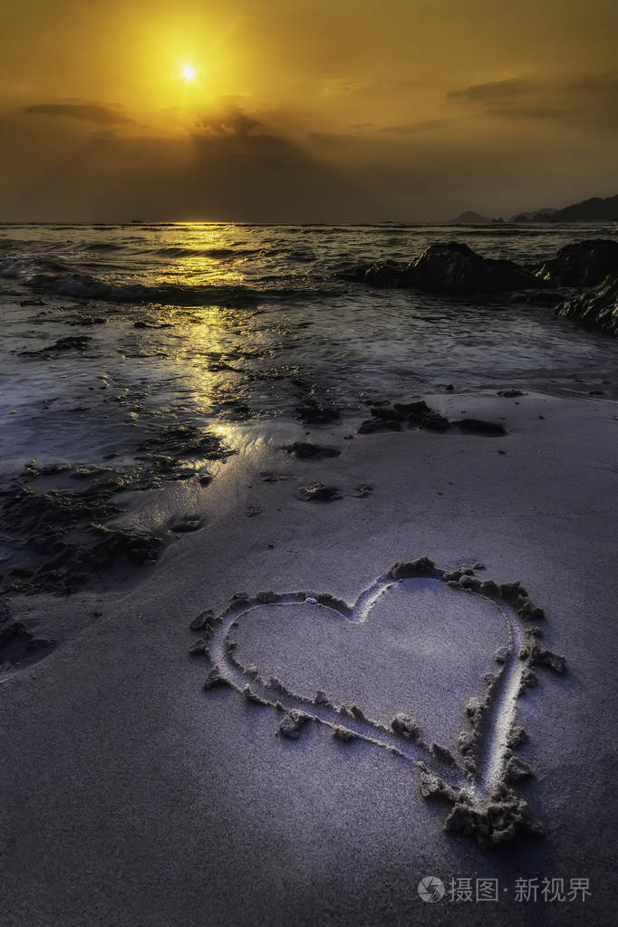 日落背景下沙滩心形浪漫景观