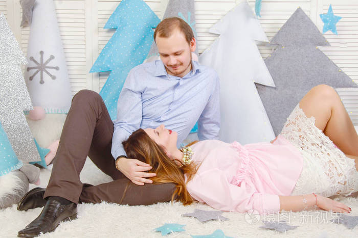 甜蜜的一对夫妻庆祝新年,在白色在白色背景上微笑