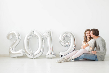 新的2019年即将到来的概念浪漫的年轻男人和女人与银色数字在白色背景