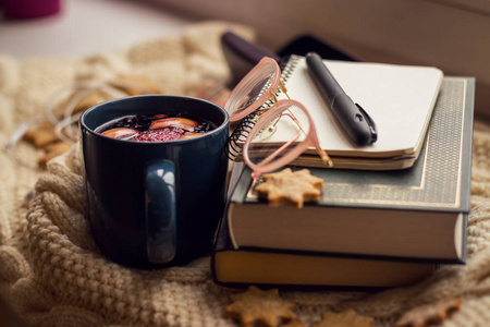 在窗台上,躺着书,记事本,眼镜,饼干,术语和杯子与覆盖葡萄酒.照片