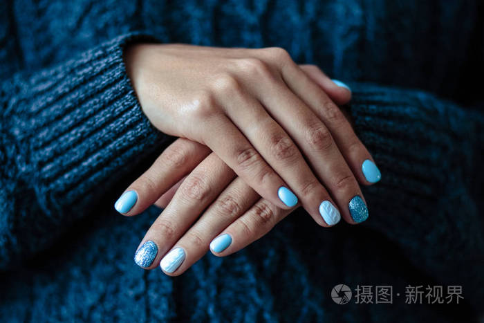 华丽的指甲粉嫩蓝色指甲油特写照片女性双手简单背景