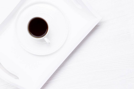 白色木制背景上的白色黑咖啡杯。 新的生命章节概念。 顶部视图复制空间